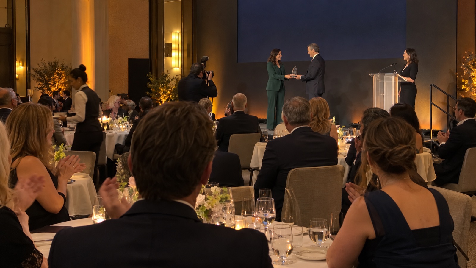 An award presentation on stage during a corporate gala dinner