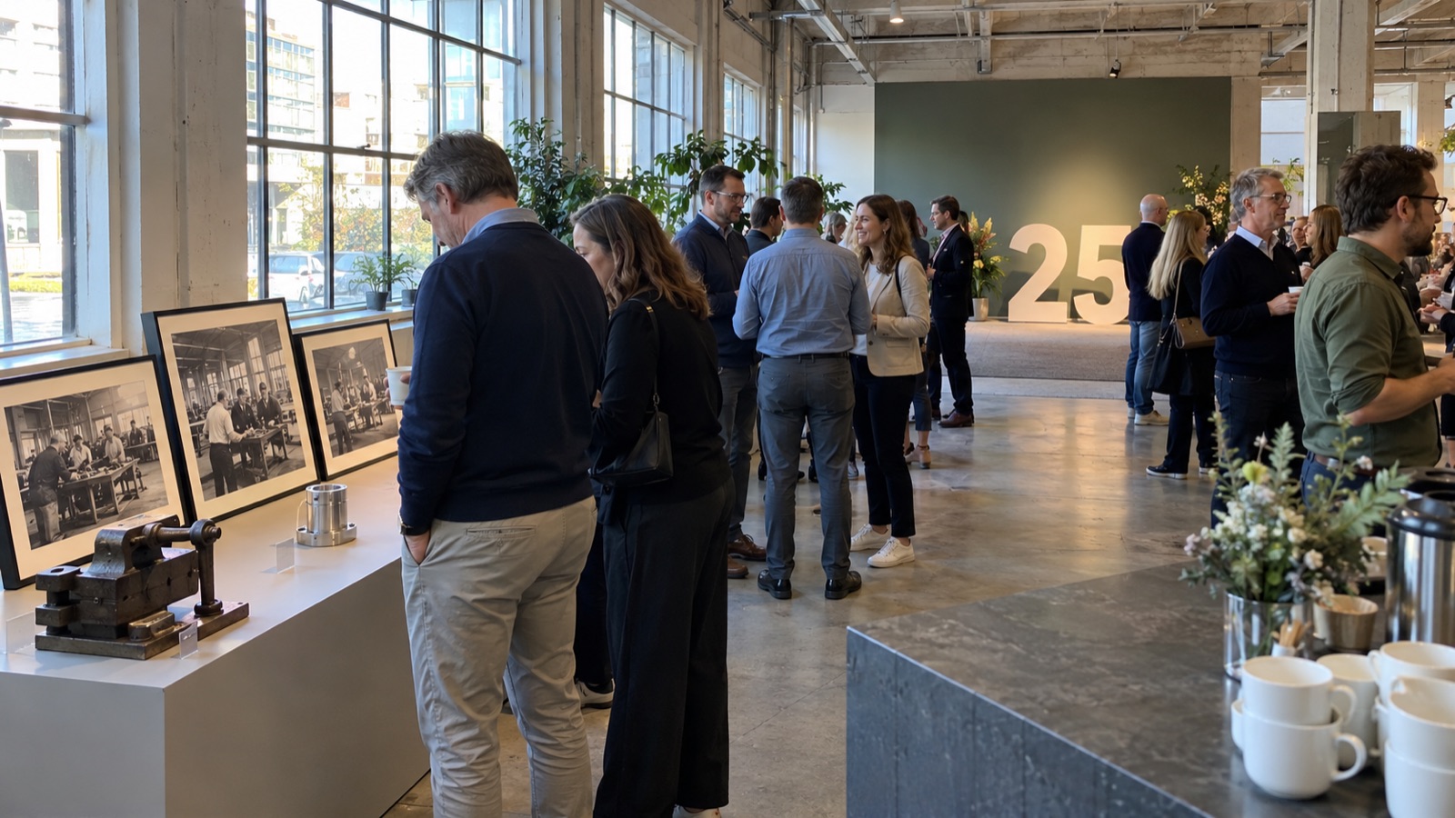 Guests viewing archive photographs and product displays at a company anniversary reception