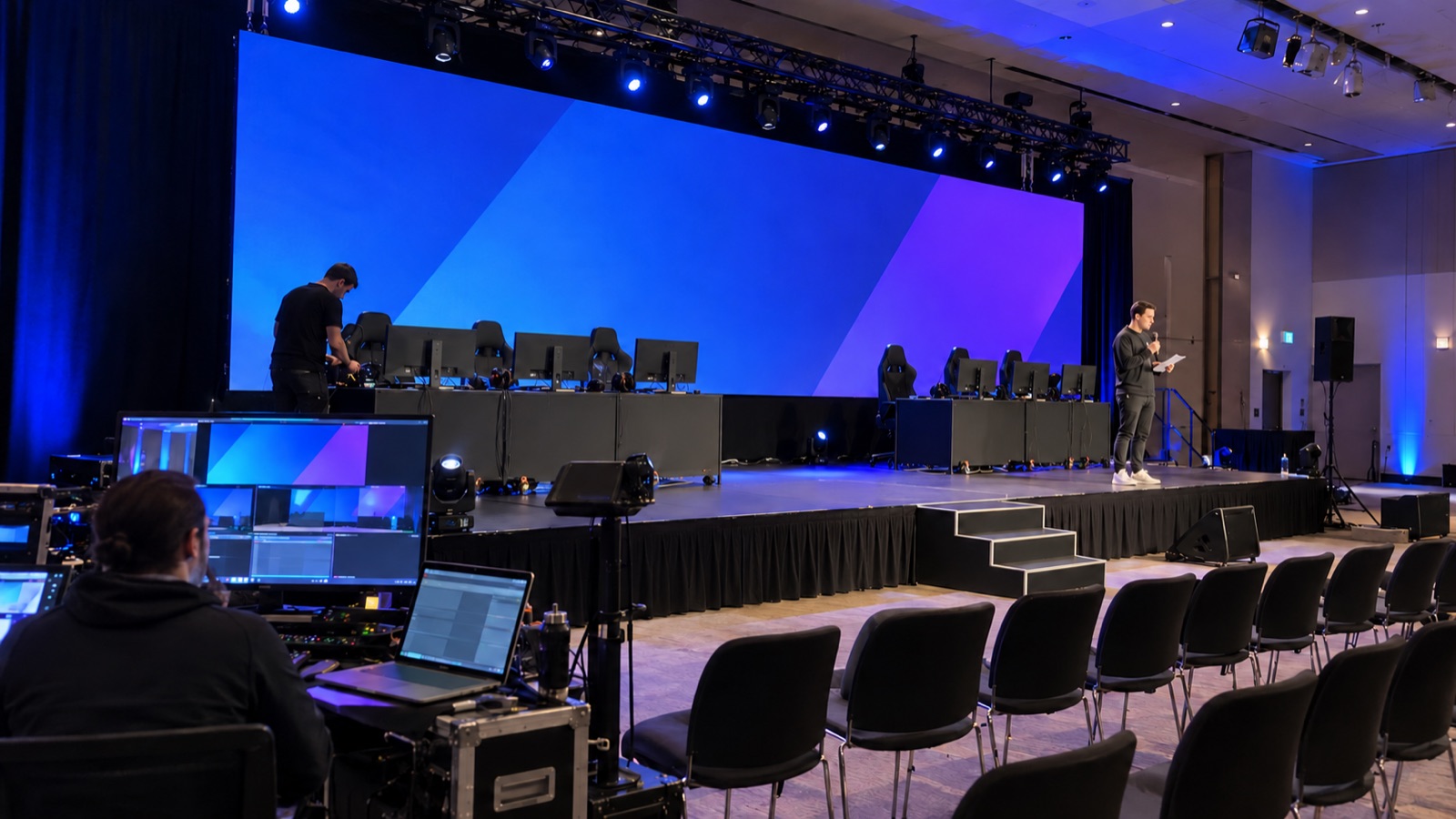 Technical rehearsal with player desks and control screens on an esports event stage