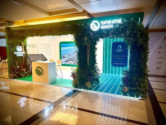 Green promotional stand with a screen and reception counter