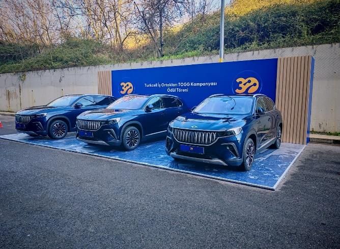 Turkcell business partner awards backdrop behind three TOGG vehicles