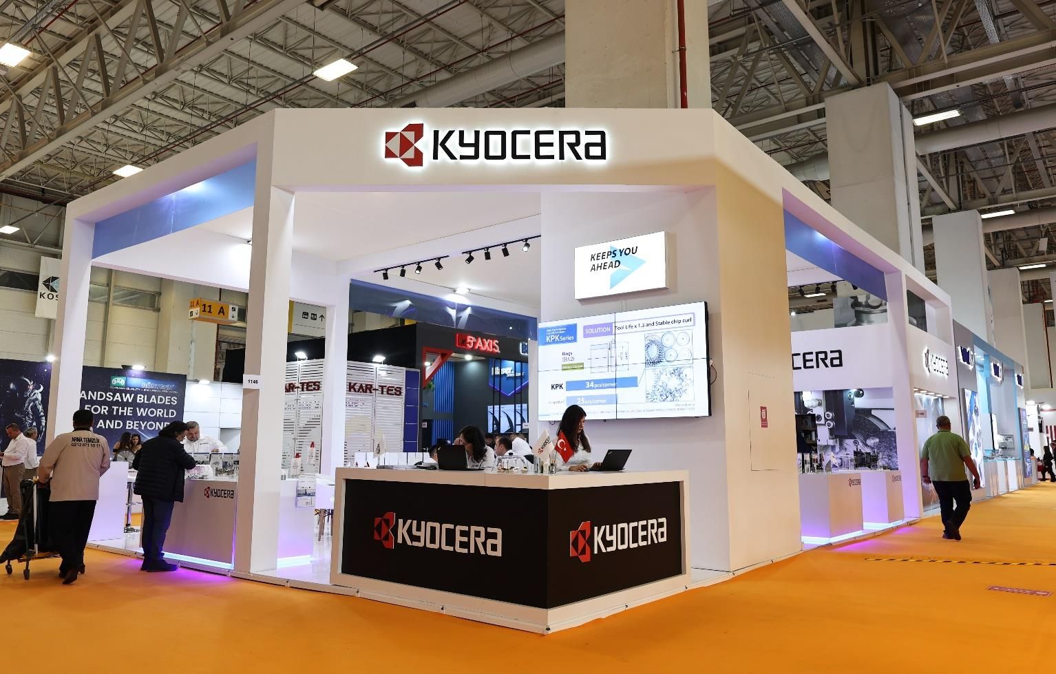 Product display cases and a visitor meeting area beneath illuminated KYOCERA signage