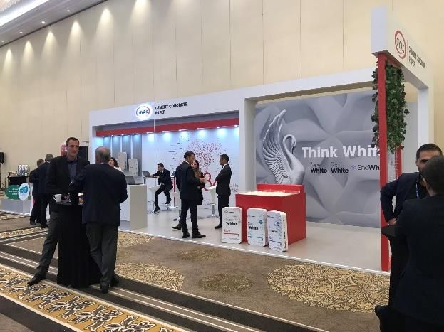 Visitors in discussion in front of a display featuring ÇİMSA and Think White signage