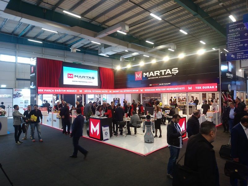 Reception counters, meeting tables and busy visitor traffic at a MARTAŞ stand